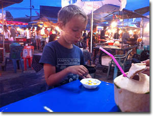 Niño comiendo en el mercado nocturno de Thong Sala